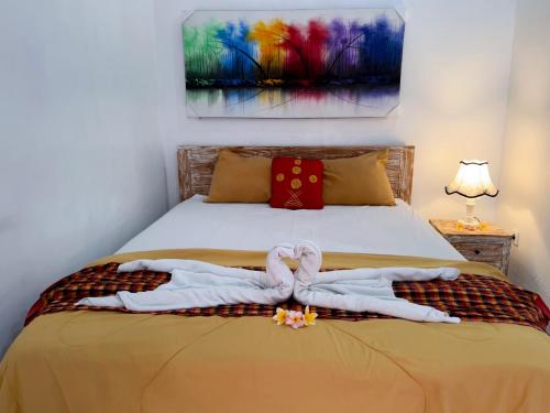 a bedroom with a bed with two towels on it at The Koi Guest House in Canggu