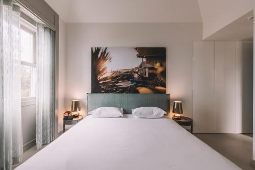 a bedroom with a large white bed with two lamps at VILLA QUINTA TORRINHA Rooms in Funchal