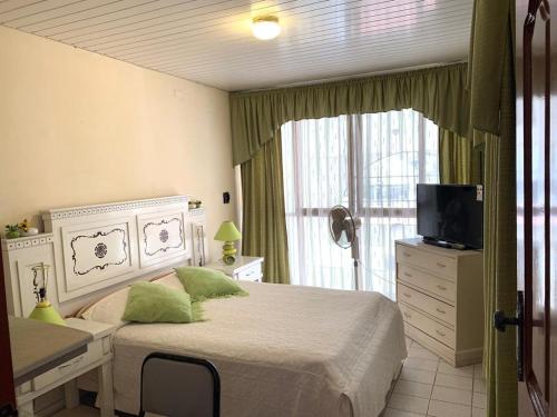 Dormitorio con cama, escritorio y TV en Residencia Estudiantil CASA TANGO, en Santa Cruz de la Sierra