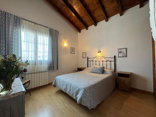 a bedroom with a bed and a large window at Casa Rio Cubas in Cubas