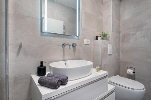 a bathroom with a sink and a toilet at Toni's Place - Sea-View & Pool in Slatine