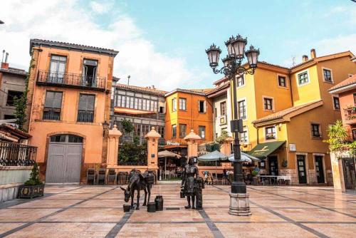 uma cidade com dois cavalos numa rua com edifícios em LUNA VERDE apartamento centro con parking em Oviedo