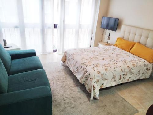 a bedroom with a bed and a blue couch at LOFT LUNA centro Oviedo con parking in Oviedo