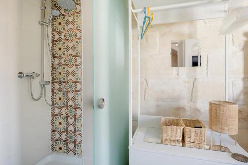a bathroom with a shower with baskets on a counter at Gallo House in Cospicua