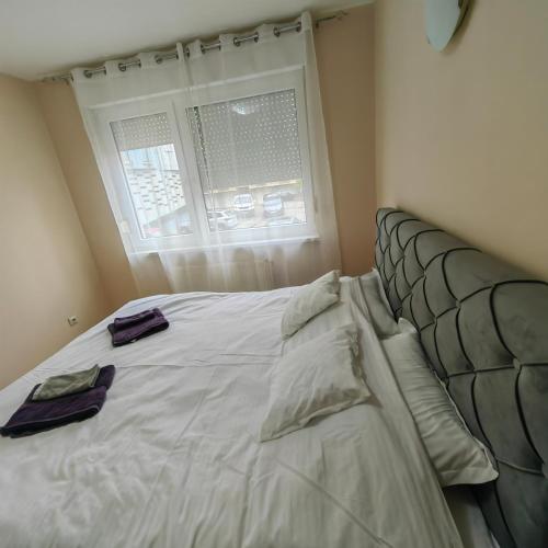 a bedroom with a bed with two towels on it at Sabac City Apartman Centre S in Šabac
