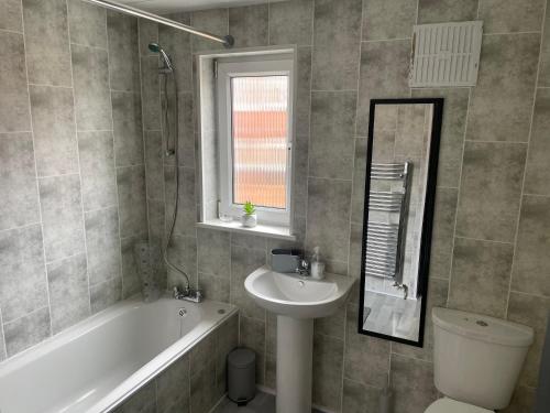a bathroom with a sink and a tub and a toilet at Quirky and Cosy Two Bed in Ferryhill Near Durham! in Ferryhill