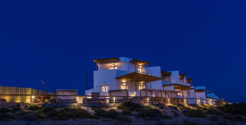 a white building with lights on it at night at SALT SUITES MILOS in Pollonia
