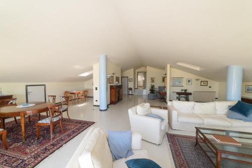 sala de estar con muebles blancos y comedor en Villa Pescara, en Pescara