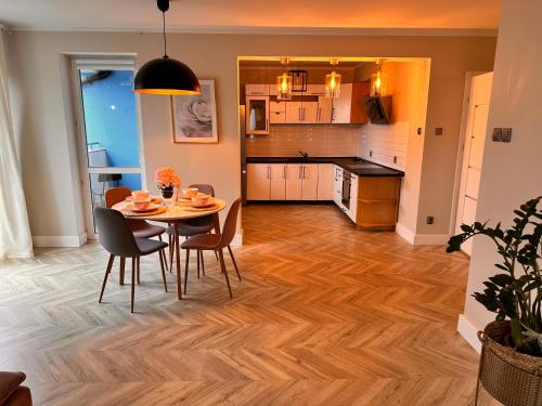 a kitchen and dining room with a table and chairs at HUDSON APARTAMENT CENTRUM in Koszalin