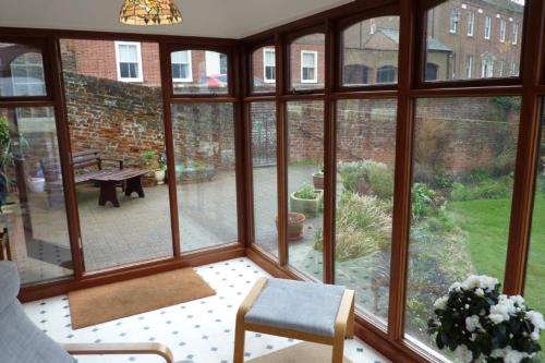 a room with a large window with a view of a patio at Ballygate Stable in Beccles