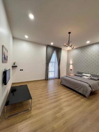 a large bedroom with a bed and a television at السكن المثالي - alsakan almithaliu in Abha