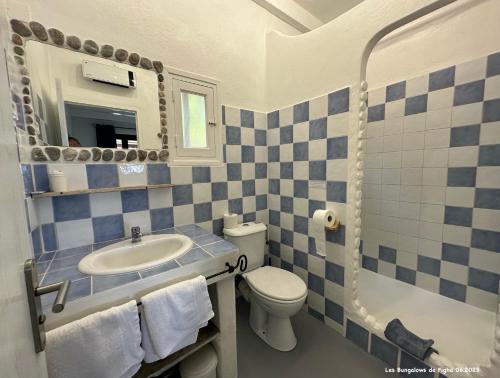 La salle de bains bleue et blanche est pourvue d'un lavabo et de toilettes. dans l'établissement Les Bungalows de Figha, à Tarcu