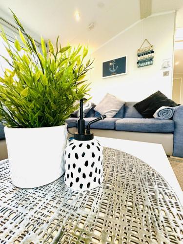 a table with a black and white vase and a plant at Ocean Breeze in Filey