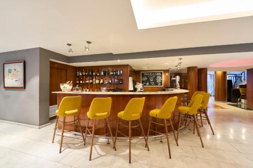 a bar with yellow bar stools in a restaurant at Catalonia Barcelona 505 in Barcelona