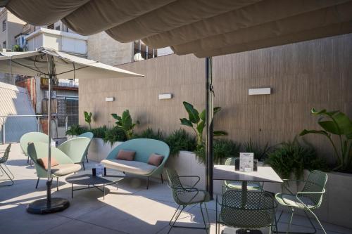 a patio with chairs and tables and umbrellas at Catalonia Barcelona 505 in Barcelona