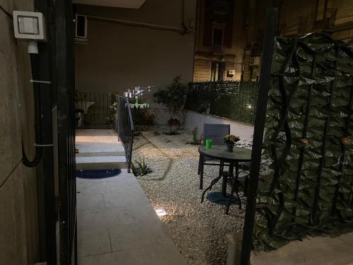 een kleine patio met een tafel en een muur bij Casa Roberta in Catania