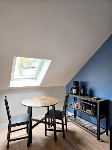 une table et des chaises dans une pièce avec une fenêtre dans l'établissement Onyx Blue, à Saint-Aignan