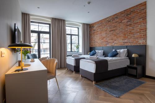 a living room with two beds and a brick wall at Carvala Boutique Apartments in Częstochowa