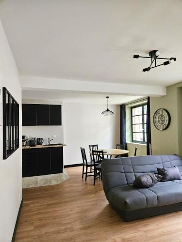 un salon avec un canapé et une cuisine dans l'établissement Onyx Black, à Saint-Aignan
