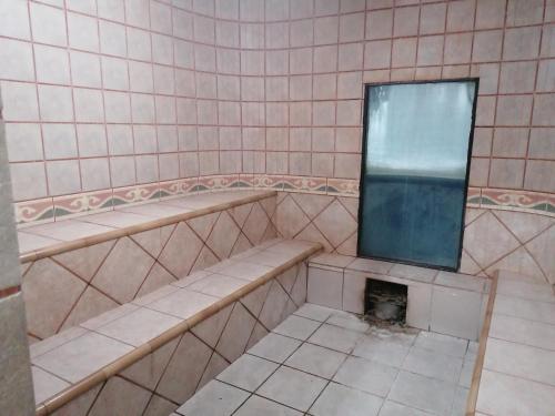 a bathroom with two benches and a mirror on the wall at Suite 5 Estrellas in Santa Cruz de la Sierra