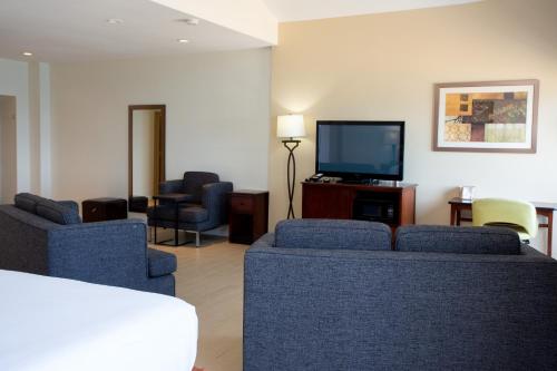 a living room with couches and a flat screen tv at Aqua Vista Resort Hotel in Virginia Beach