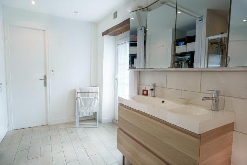 une salle de bain avec un lavabo et un miroir dans l'établissement Villa Capucine, à Saint-Hilaire-les-Andrésis
