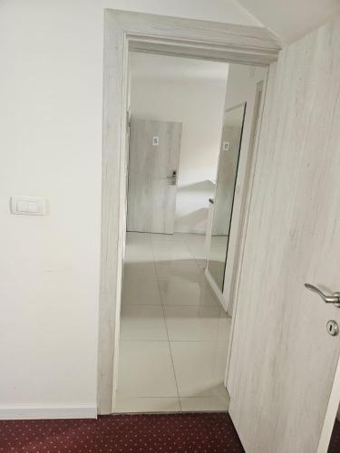 a hallway with a mirror in a white room at ForS Konak Apartments in Belgrade