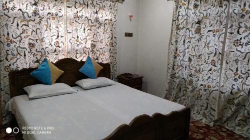 Bett in einem Zimmer mit Vorhängen und einem Bett sidx sidx sidx sidx in der Unterkunft The Hotel "Shafeeq" Across jawahar bridge in Srinagar