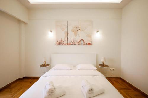 a white bedroom with a white bed and two lamps at Cozy 3 Bedroom Retreat next to Kolonaki - Greecing in Athens