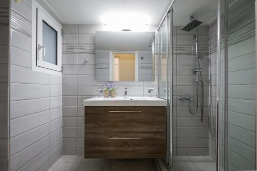 a bathroom with a sink and a shower at Cozy 3 Bedroom Retreat next to Kolonaki - Greecing in Athens