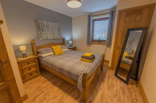 Un dormitorio con una cama con almohadas amarillas. en Quay Head View Aparthotel en Stranraer