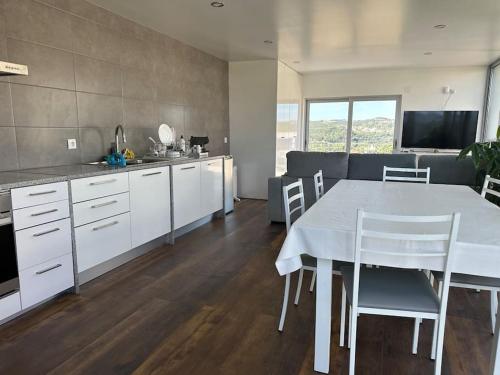 uma cozinha e sala de jantar com uma mesa branca e cadeiras em Penthouse com Jacuzzi em Coimbra