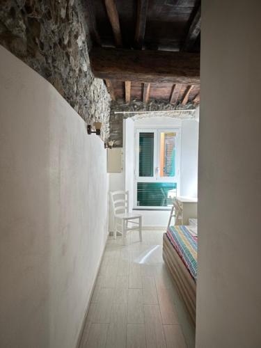 a hallway with a bed and a window in a room at Locanda Ca Dei Duxi in Riomaggiore