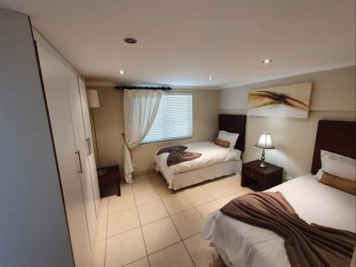 a hotel room with two beds and a window at Nautica in Mossel Bay