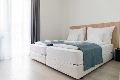 a white bedroom with a large bed with white pillows at Farkas Villa in Mórahalom