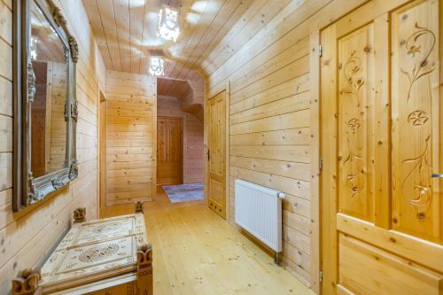 pasillo con paneles de madera, lavabo y espejo en HUBA- góralski dom, en Huba