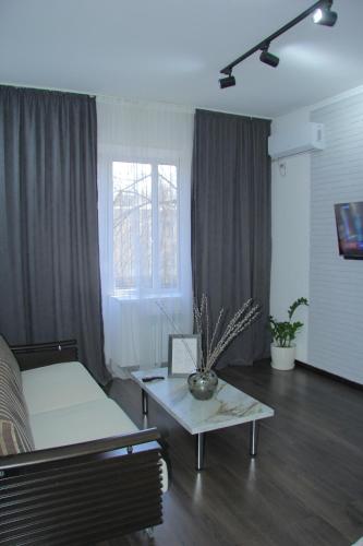 a living room with a couch and a coffee table at Апартаменты Центр Медеуский Район in Almaty