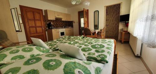 um quarto com uma cama com um edredão verde e branco em Ferienwohnung in arnowska mit Grill und Garten em Żarnowska
