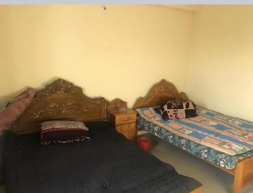 a bedroom with two beds and a dresser in it at 157 Sorno Shika Ekanto niketon in Sylhet