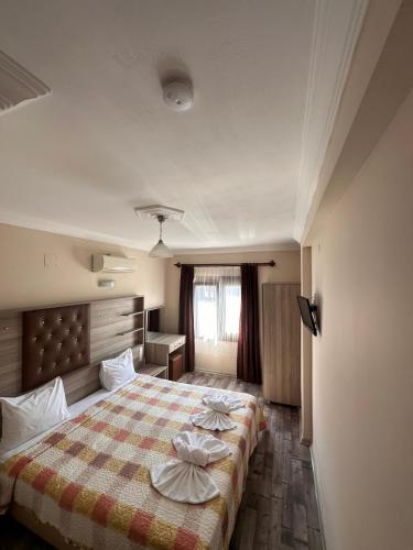 a bedroom with a bed with pillows on it at Akay Hotel in Selcuk