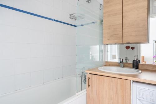 ein Bad mit einem Waschbecken und einer Dusche in der Unterkunft Appartement Lumineux avec Balcon à Courbevoie in Courbevoie