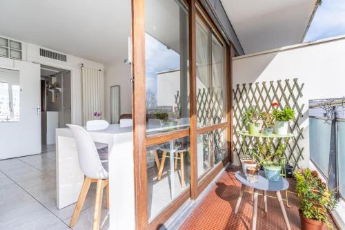 een balkon met een tafel en stoelen in een kamer bij Appartement Lumineux avec Balcon à Courbevoie in Courbevoie