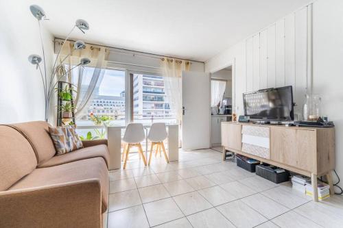 ein Wohnzimmer mit einem Sofa und einem TV in der Unterkunft Appartement Lumineux avec Balcon à Courbevoie in Courbevoie