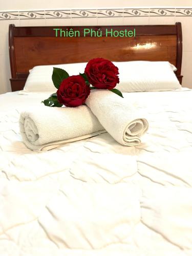 a towel with two roses on top of a bed at Thiên Phú Hostel Cần Thơ in Cái Răng