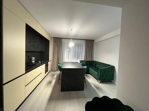 a living room with a green couch and a table at FLH - Robella Apartment in Sibiu