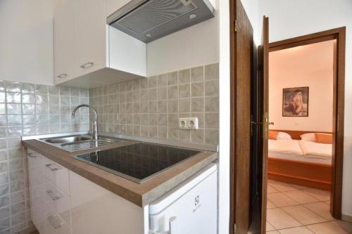 uma cozinha com um lavatório e um quarto com uma cama em Wohnung in Pješčana Uvala mit gemeinschaftlichem Pool und Grill em Pula