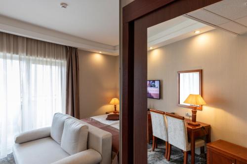 モーラハロムにあるColosseum Hotelのベッドと鏡が備わるホテルルーム