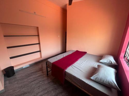 a small bedroom with a bed and a window at HostelVK Gokarna in Gokarna
