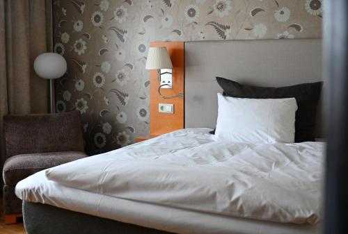 a bedroom with a white bed and a chair at Clarion Hotel Oslo Airport in Gardermoen
