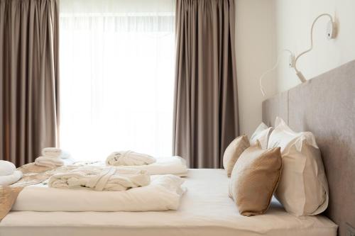 1 dormitorio con cama con almohadas y ventana en Top Apartments Opatija, en Dobreć